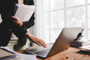 Une femme d'affaires avec beaucoup de dossiers, travaillant dur dans son bureau
